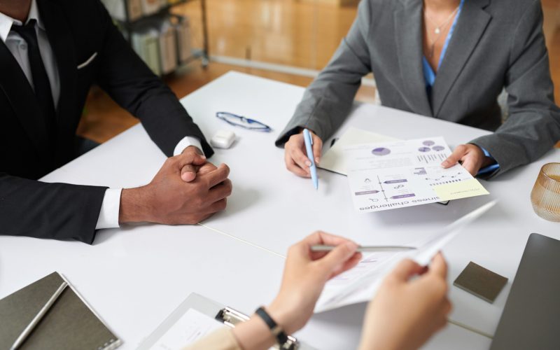 Hands of entrepreneurs discussing charts and reports at meeting